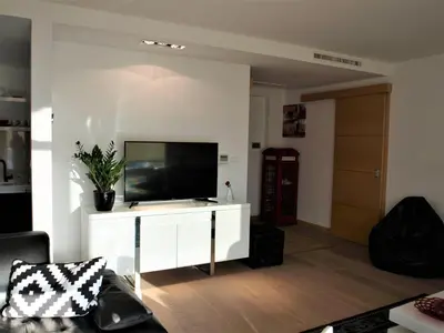 a living room with a television on a white cabinet at Red Lux in Budva