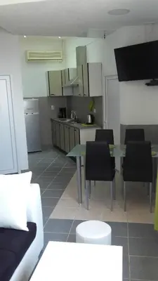 a living room with a table and chairs and a kitchen at Apartments Petrovic in Krimovice