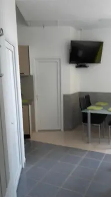 a room with a table and a tv on a wall at Apartments Petrovic in Krimovice