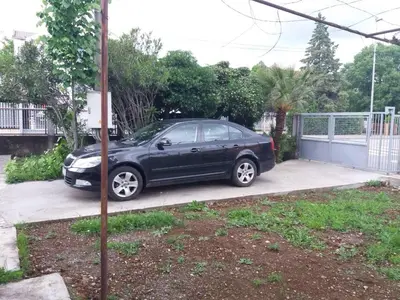a black car parked in a driveway at Apartment La Romana in Podgorica