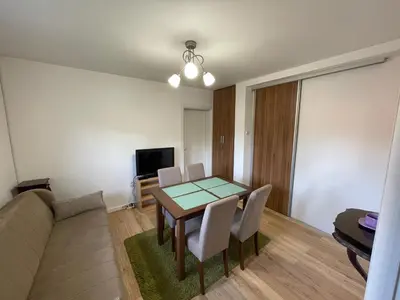 a living room with a table and a couch at Apartment La Romana in Podgorica