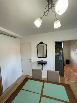 a room with a table and chairs and a mirror at Apartment La Romana in Podgorica