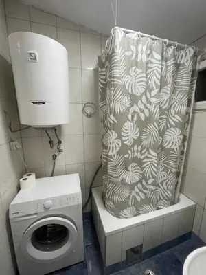 a bathroom with a washing machine and a shower curtain at Apartment Lazar & Marco in Podgorica