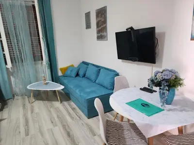 a living room with a blue couch and a table at Apartments Sandra 2 in Kotor