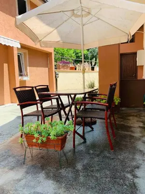 a patio table and chairs with an umbrella at Apartments Sandra 2 in Kotor