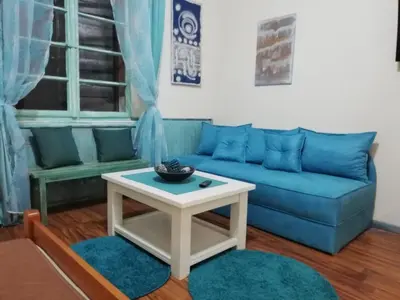 a living room with a blue couch and a table at Apartments Sandra 2 in Kotor