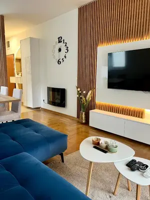 a living room with a blue couch and a tv at Bojovic's Apartment in Budva