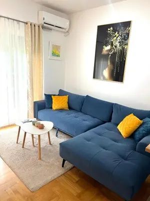 a blue couch in a living room with a table at Bojovic's Apartment in Budva