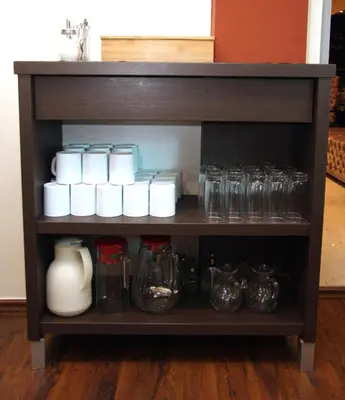 a shelf with several glasses and bottles on it at Vila V Lux Apartments in Petrovac na Moru