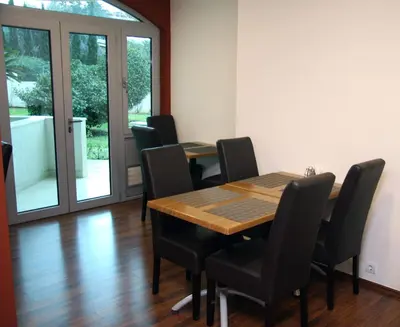 a dining room with a wooden table and chairs at Vila V Lux Apartments in Petrovac na Moru