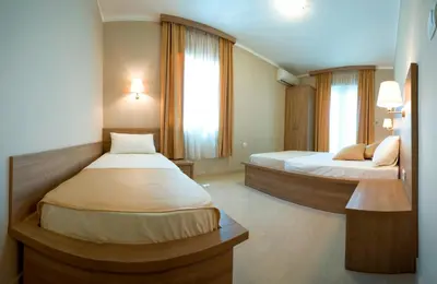 a hotel room with two beds and two windows at Vila V Lux Apartments in Petrovac na Moru