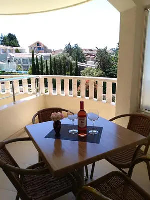 a table with a bottle of wine and two glasses at Vila V Lux Apartments in Petrovac na Moru