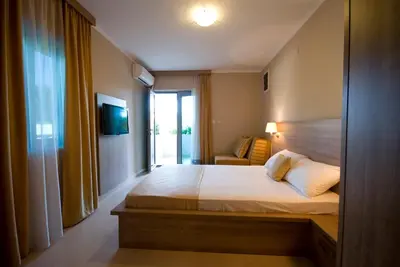 a bedroom with a bed and a tv and a couch at Vila V Lux Apartments in Petrovac na Moru