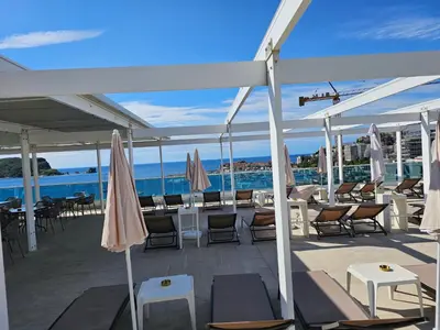 a patio with tables and chairs and umbrellas at Apartments Menuet in Budva