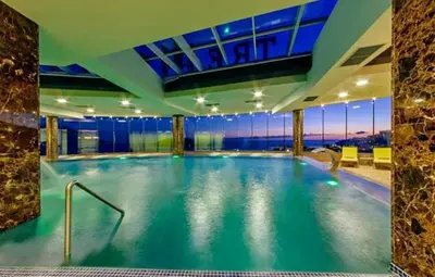 a large swimming pool in a building with a view at Apartments Menuet in Budva