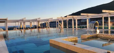 a building with a swimming pool with a fountain at Apartments Menuet in Budva