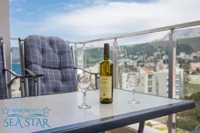 a bottle of wine sitting on a table with two glasses at Sea Star Apartment in Dobra Voda