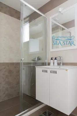 a bathroom with a shower and a sink at Sea Star Apartment in Dobra Voda