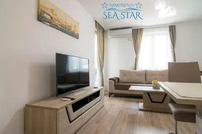 a living room with a television and a couch at Sea Star Apartment in Dobra Voda