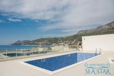 a swimming pool on top of a building with a view of the ocean at Sea Star Apartment in Dobra Voda
