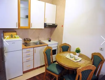 a kitchen with a table and chairs and a sink at Apartment Sara in Podgorica