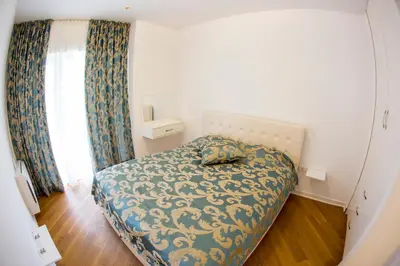 a bedroom with a bed with a blue and white blanket at Apartman Anna Tre Canne Budva in Budva