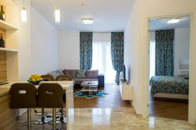 a living room with a couch and a table and chairs at Apartman Anna Tre Canne Budva in Budva