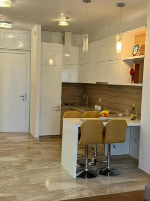 a kitchen with a table and chairs in a room at Apartman Anna Tre Canne Budva in Budva