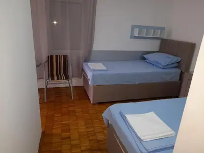 a small room with two beds and a chair at Ana in Budva