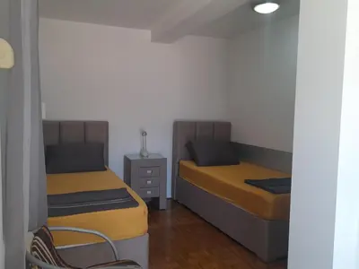 a room with two beds and a chair in it at Ana in Budva