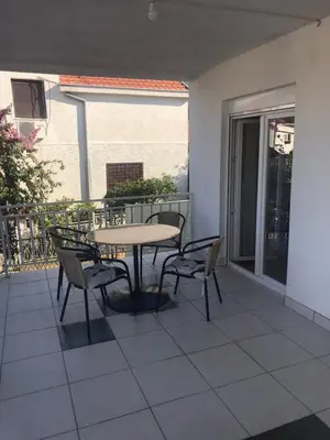 a patio with a table and chairs on a balcony at Apartmani Palma in Sutomore