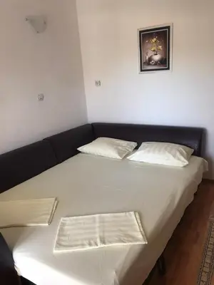 a large white bed with two pillows on it at Apartmani Palma in Sutomore