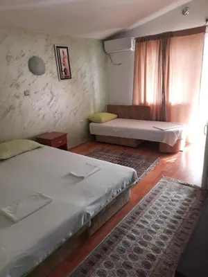 a room with two beds and a couch in it at Apartmani Palma in Sutomore