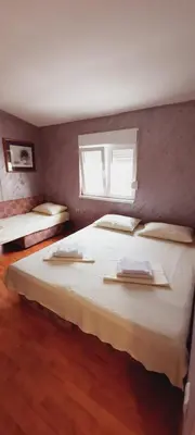 a bedroom with two beds and a window at Apartmani Palma in Sutomore