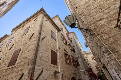 an old stone building with windows on a street at G-Apart in Kotor