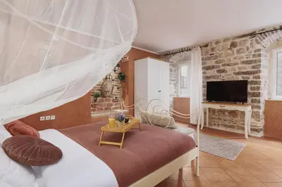 a bedroom with a bed with a mosquito net at G-Apart in Kotor