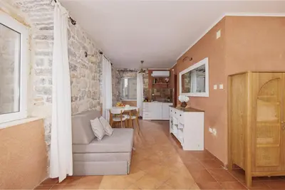 a living room with a couch and a stone wall at G-Apart in Kotor