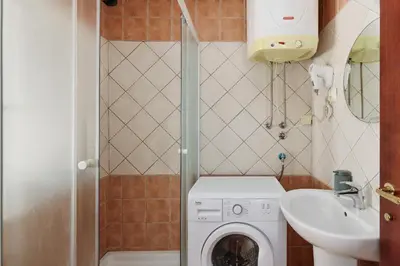 a small bathroom with a washing machine and a sink at G-Apart in Kotor