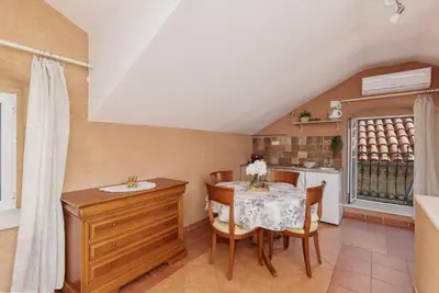 a kitchen and dining room with a table and chairs at G-Apart in Kotor