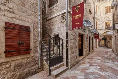 an alley in an old town with a flag on a building at G-Apart in Kotor