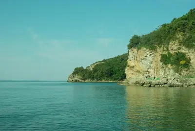 a large body of water next to a rocky cliff at Miracle in Budva