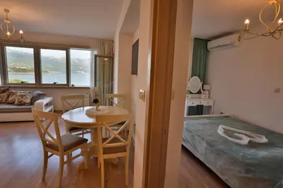 a living room with a table and chairs and a bedroom at Miracle in Budva