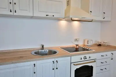 a kitchen with white cabinets and a sink and a stove at Miracle in Budva