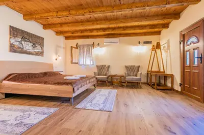 a bedroom with a bed and a table and chairs at Ethno Lodge AB in Virpazar