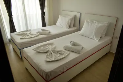 two beds with white towels and bows on them at Lux Kalimera Apartments in Ulcinj