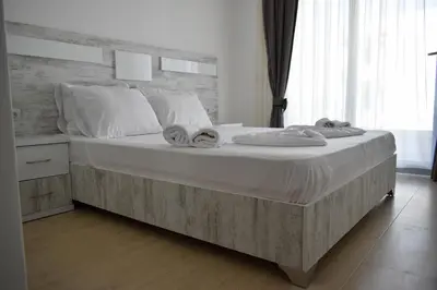 a bedroom with a large bed with towels on it at Lux Kalimera Apartments in Ulcinj