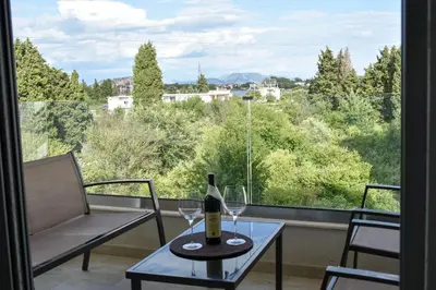 a bottle of wine on a table in front of a window at Lux Kalimera Apartments in Ulcinj