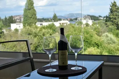 a bottle of wine sitting on a table with two glasses at Lux Kalimera Apartments in Ulcinj