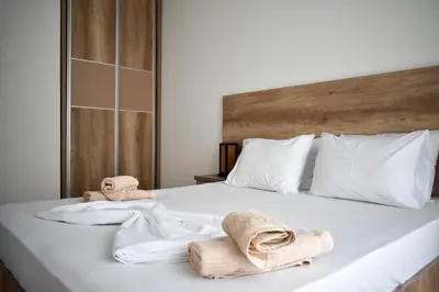 a white bed with towels and towels on it at Lux Kalimera Apartments in Ulcinj