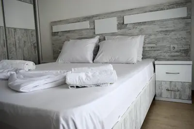 a large white bed with two towels on it at Lux Kalimera Apartments in Ulcinj